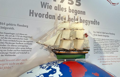 På en stor model af kloden står et modelsejlskib. Nogle af landene er farvet røde. Det drejer sig om lande og hertugdømmer, der tilhørte den danske helstat, dengang skibe fra Flensborg sejlede til Dansk-Vestindien.