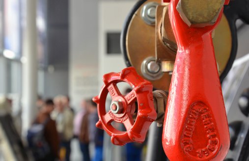 Detaljeoptagelsen af kedlen, der står i teknikhallen, viser en håndtag og et lille hjul. Begge er røde og fremstår meget flot i kontrast til den ellers sorte kedel.