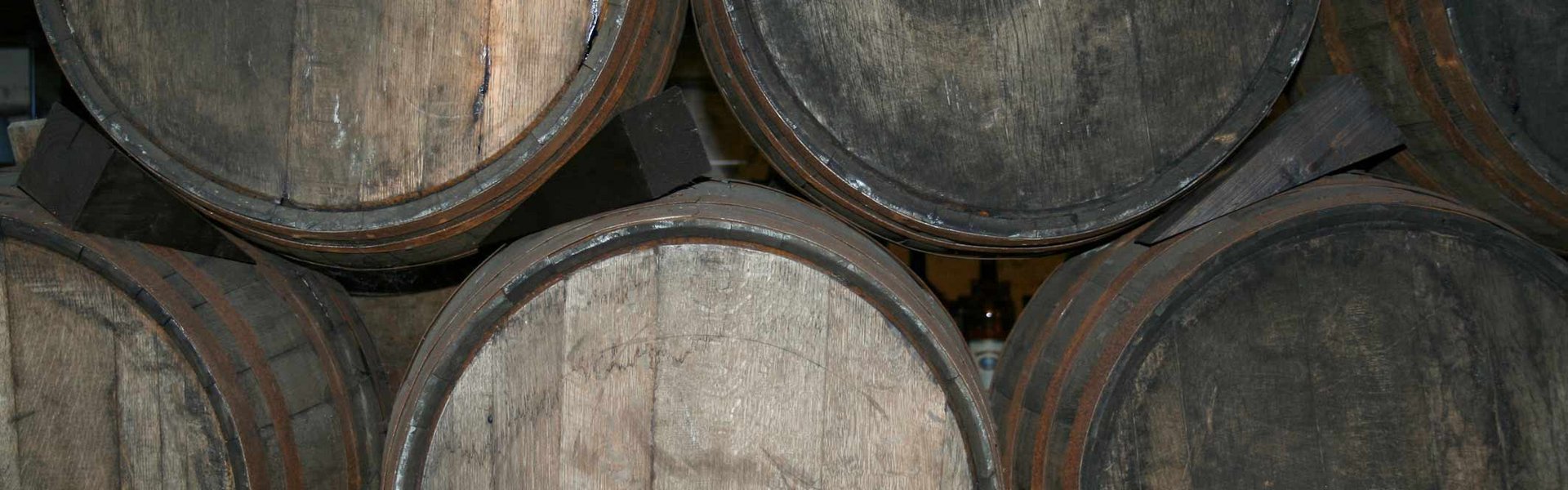 I Flensborgs Søfartsmuseums kælder ligger romfade pænt stablet. Her ses et nærbillede af installationen. Man ser seks fade, der ligger på siden, så man kun kan se deres bunde.