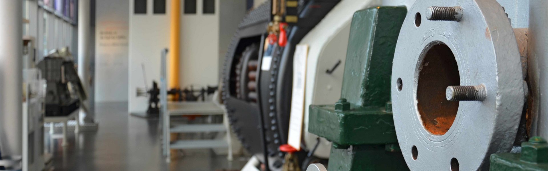 Kig gennem teknikhallen. Til højre og venstre langs væggene står forskellige maskiner. I forgrunden ses også en stor maskine. I baggrunden ses skibets bro.