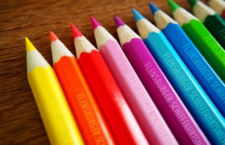 Auf einem Tisch liegen Buntstifte. Alle sind mit dem Schriftzug „Flensburger Schifffahrtsmuseum“ geprägt.