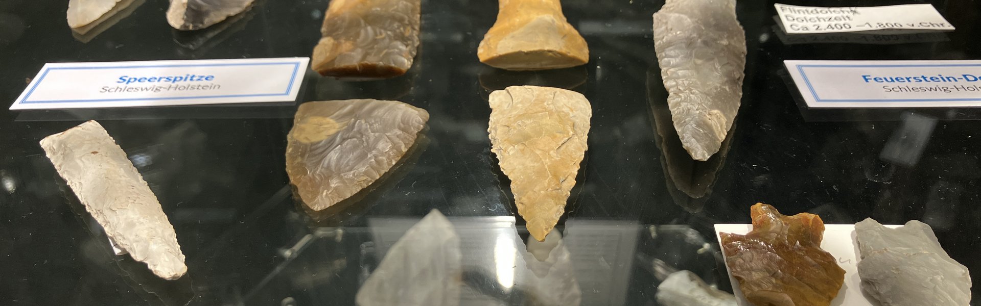 Das Foto zeigt steinzeitliche Funde im Eiszeit-Haus. Es sind verschiedene Pfeil- und Speerspitzen zu sehen.