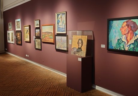 Es ist ein Raum zu sehen, in dem mehrere Bilder einer Ausstellung hängen.