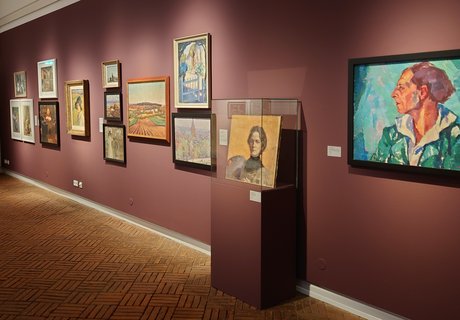 Es ist ein Raum zu sehen, in dem mehrere Bilder einer Ausstellung hängen.