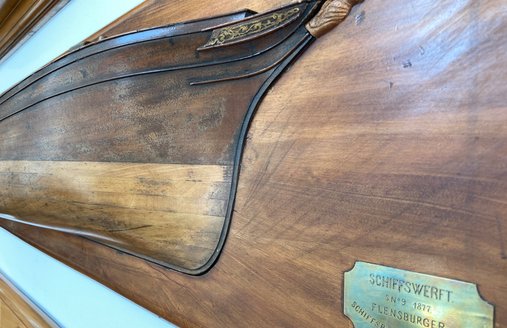 An einer Wand hängt ein Halb-Schiff der FSG. Das ist ein Modell von einem halben Schiff. 