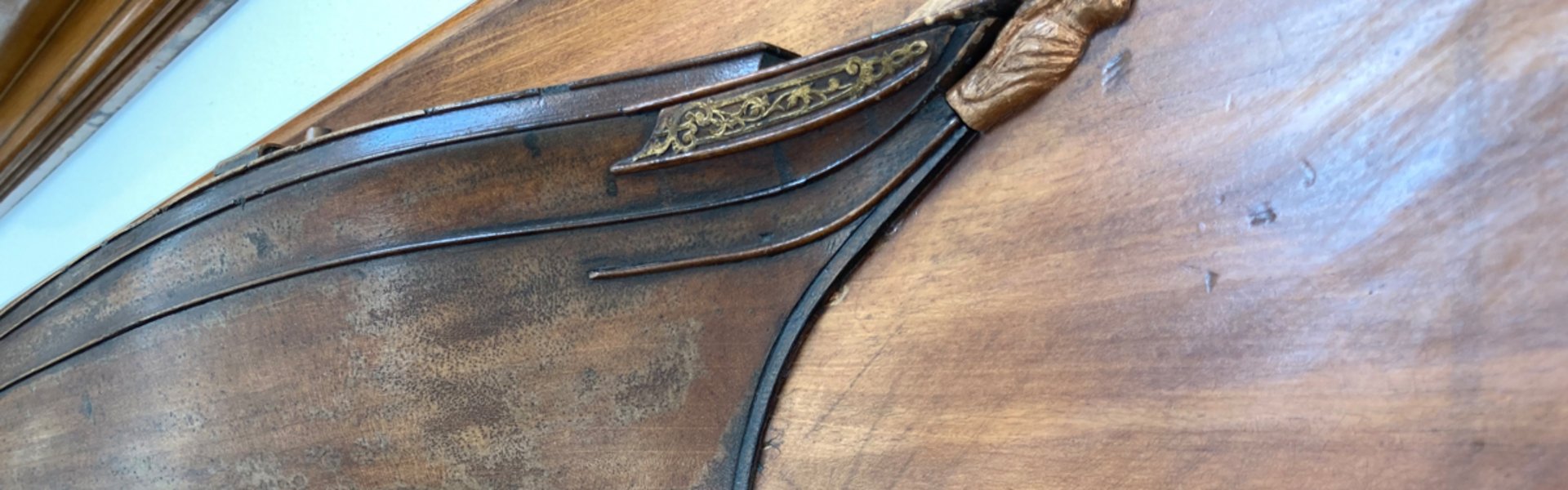 På en væg hænger et halvskib fra FSG. Det er et nærbillede.