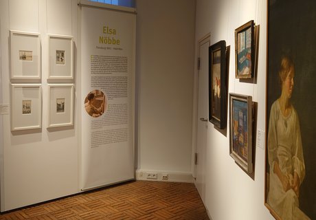 Es ist ein Raum zu sehen, in dem mehrere Bilder einer Ausstellung hängen.