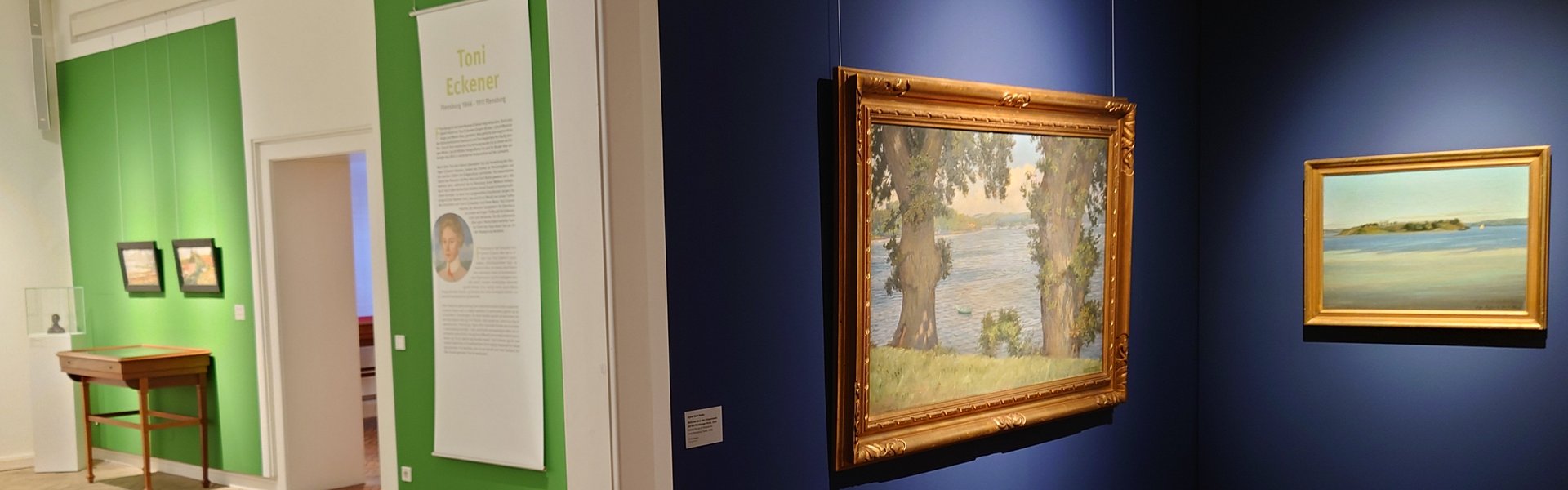 Es ist ein Raum zu sehen, in dem mehrere Bilder einer Ausstellung hängen.