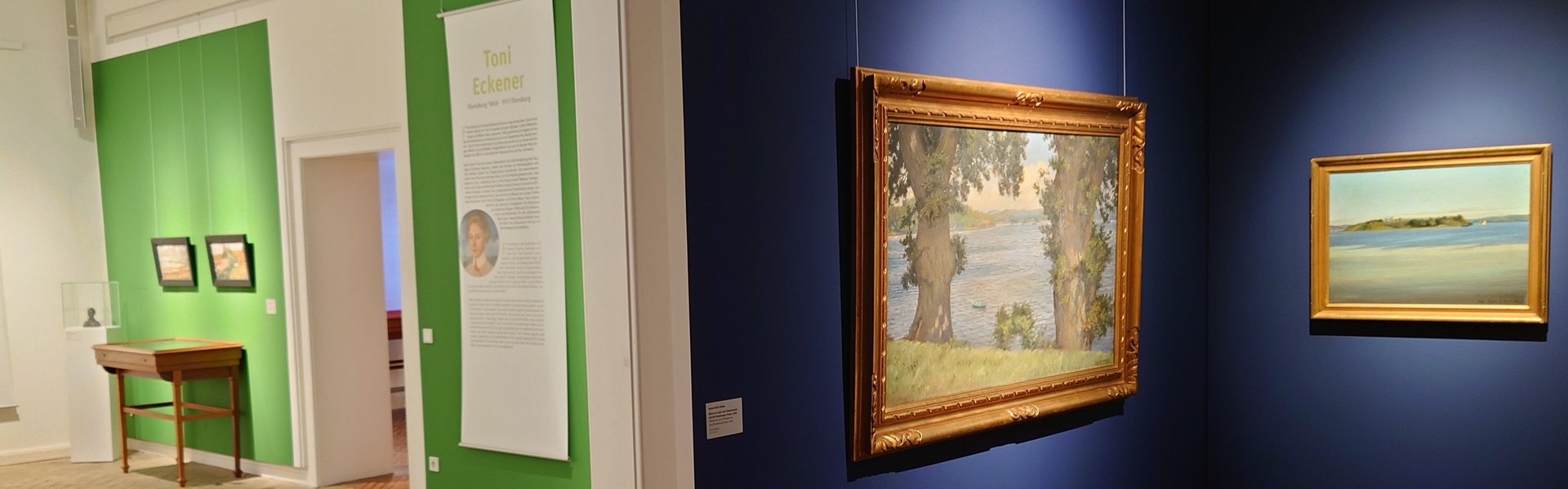 Es ist ein Raum zu sehen, in dem mehrere Bilder einer Ausstellung hängen.