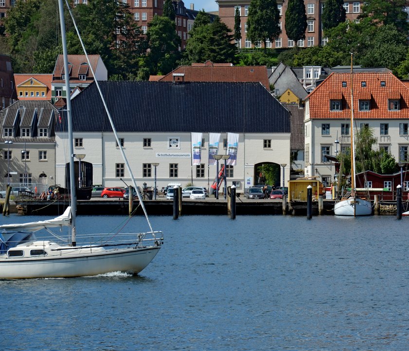Foran hovedbygningen til Flensborg Skibsfartsmuseum står et markant søtegn. Tønden er malet rød og sort og bærer desuden påskriften Holnis. Der er også malet et 10-tal på søtønden. På facaden til Skibsfartsmuseet hænger et skilt med påskriften: Schiffahrtsmuseum. Over det hænger et ur. Museets vinduer har alle sprosser.