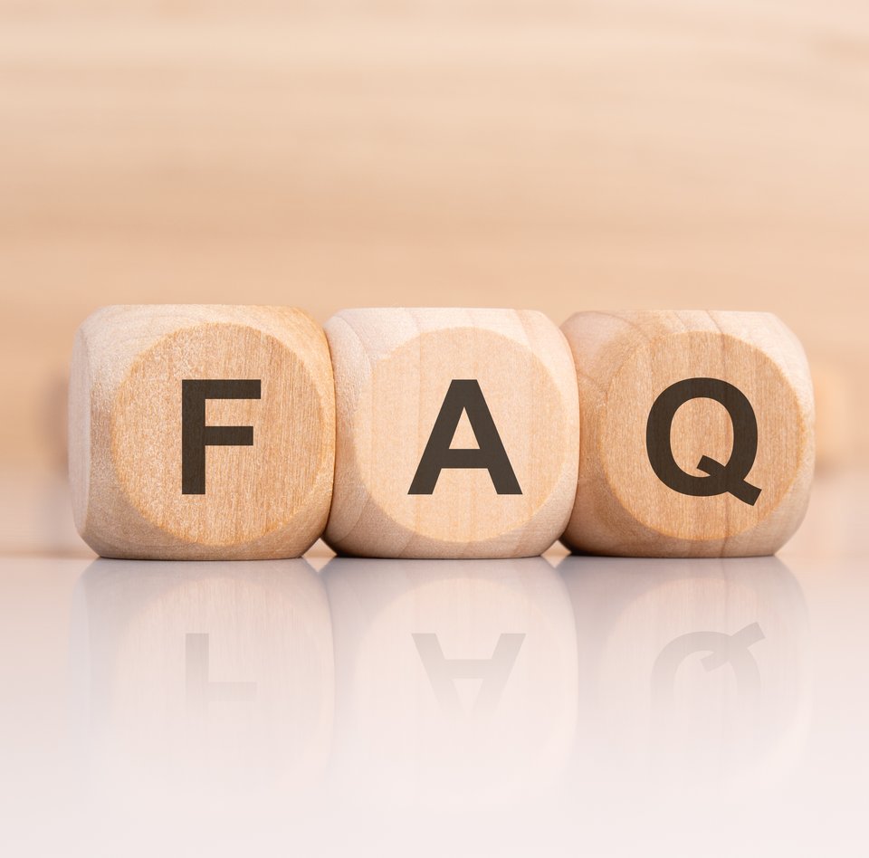 Detailaufnahme von drei Holzwürfel, auf denen die Buchstaben F, A und Q stehen. Der helle Hintergrund ist verschwommen. Dort können weitere Würfel erahnt werden.